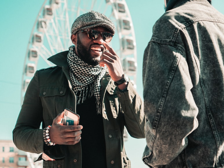 Two guys talking on a walk through the city.