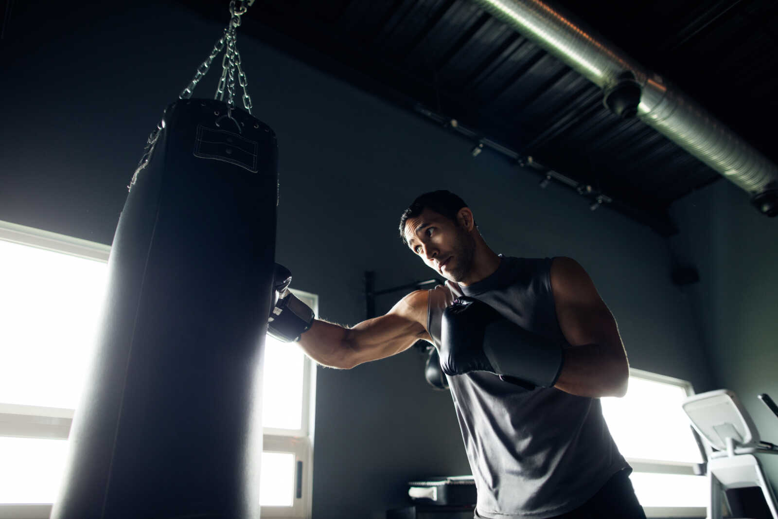 Concentrated young man box training by himself in the gym