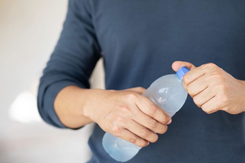 Man Hand Holding Cool Fresh Drinking Water Bottle