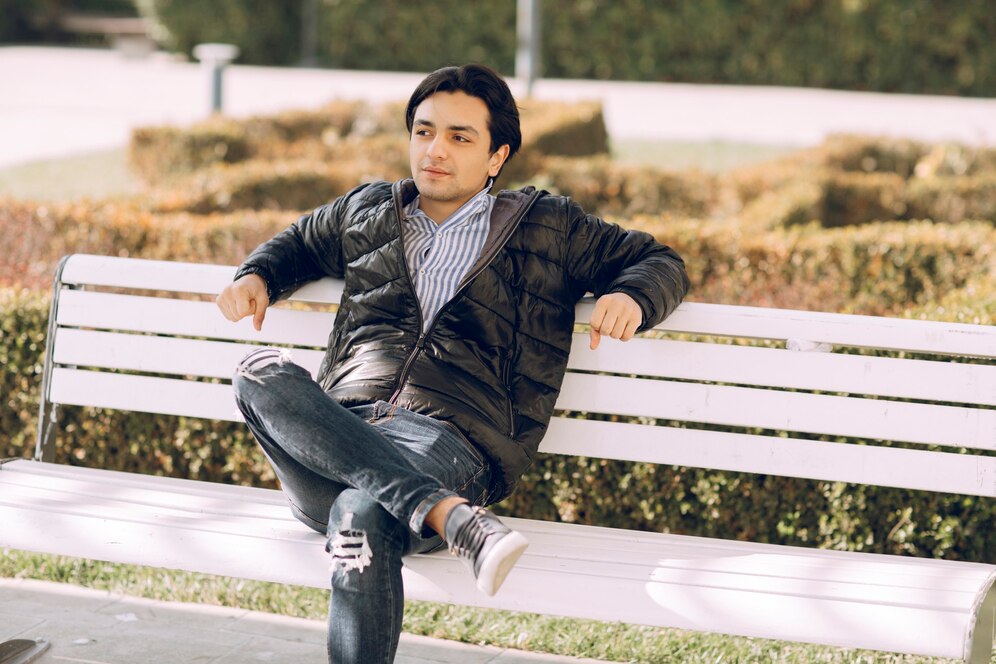 Single man sitting on the bench in the park 